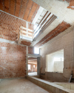 Complesso residenziale contemporaneo con facciate in calcestruzzo a vista, attici in XLAM e hall a doppia altezza
